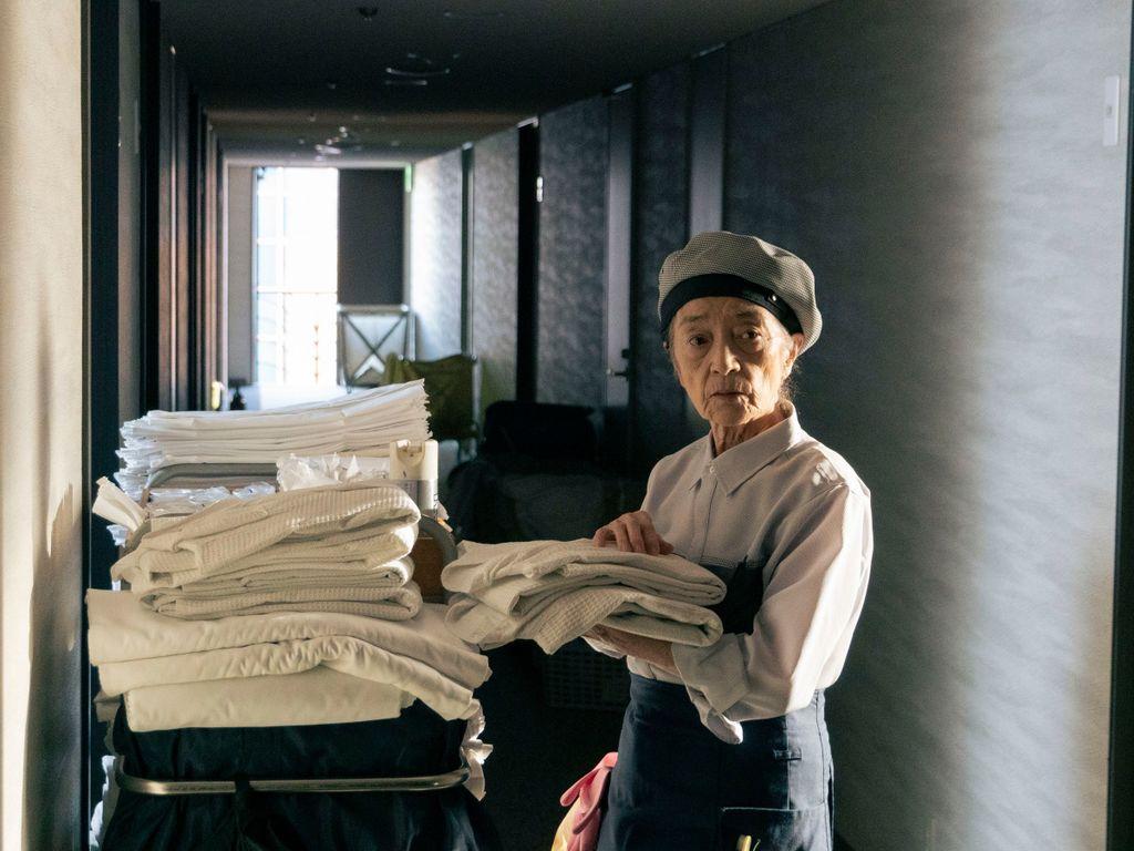 Une femme âgée en uniforme de lingère dans un couloir d'hôtel, image issue du film Plan 75 de Chie Hayakawa, EUROZOOM